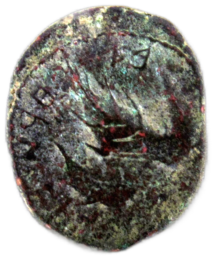 Moneda de bronce gastada, con relieves apenas visibles