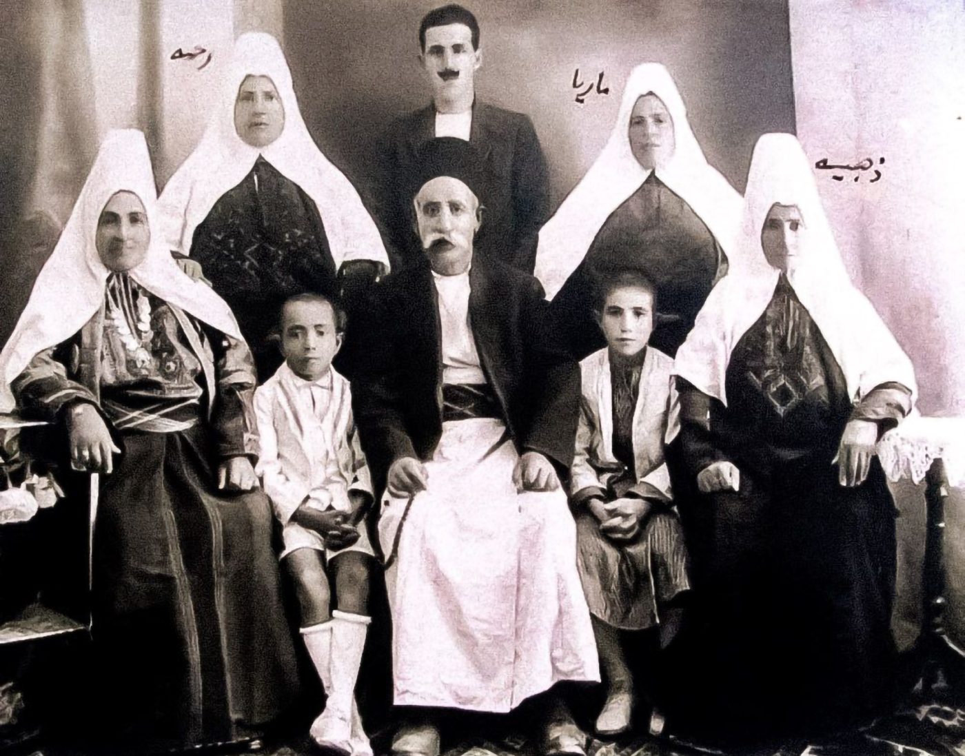 Retrato antiguo de una familia; las mujeres llevan un tocado blanco
