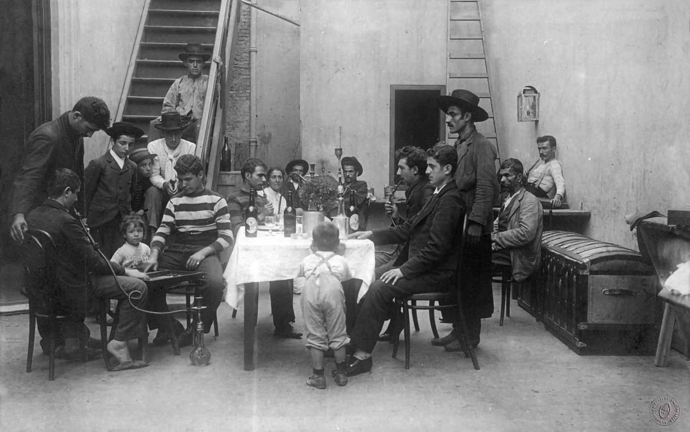 Grupo de hombres y niños reunidos en torno a una mesa en un local