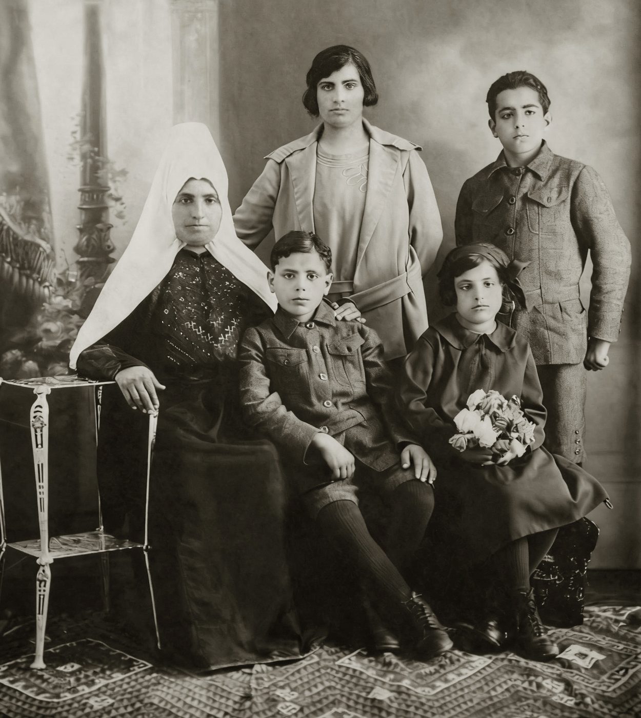 Retrato antiguo de una madre con tocado blanco y sus cuatro hijos
