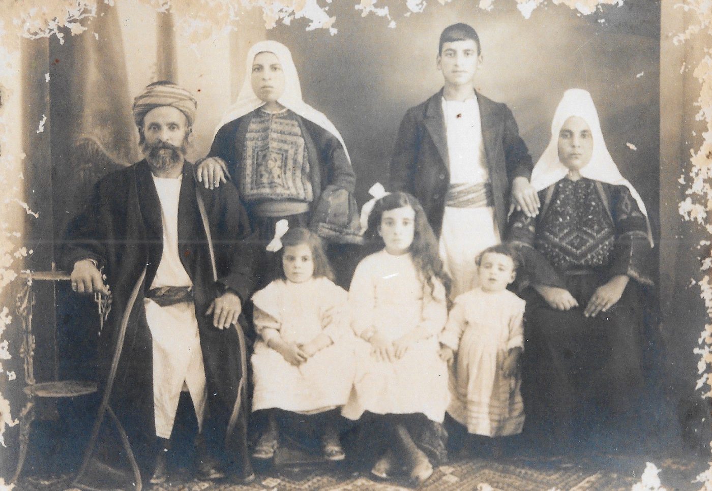 Retrato antiguo de una familia con tres niñas vestidas de blanco