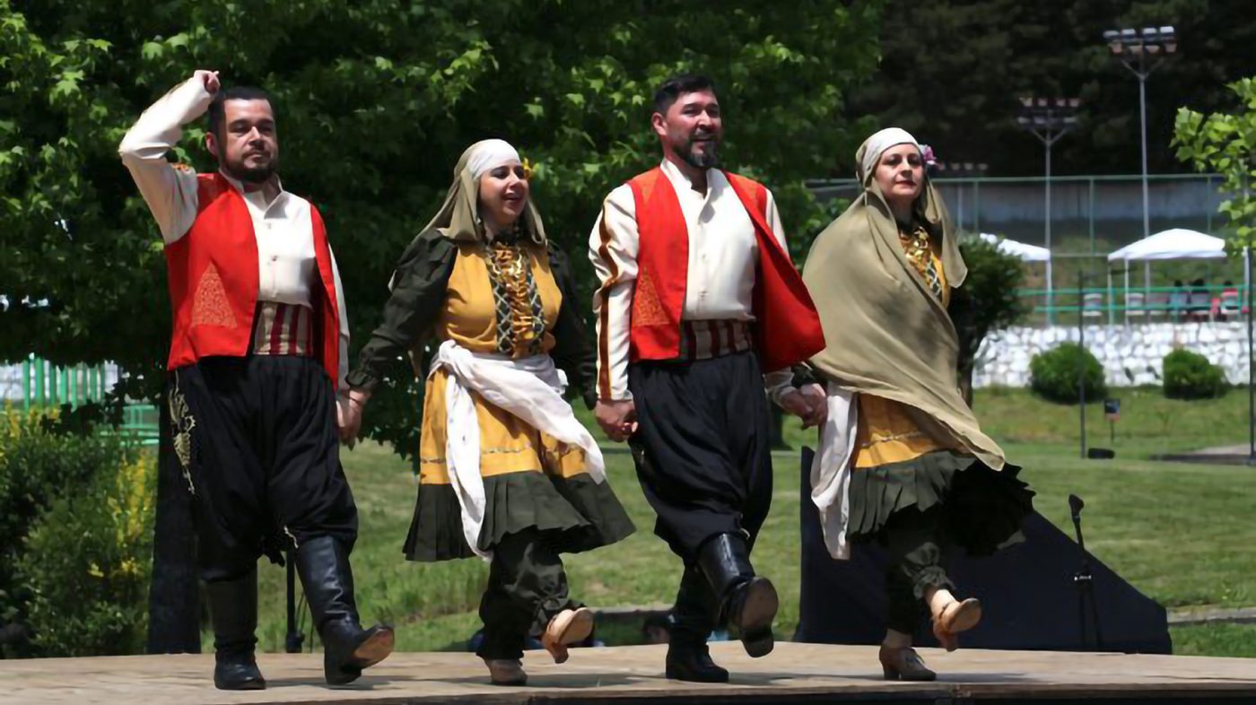 Bailarines con trajes tradicionales danzan al aire libre