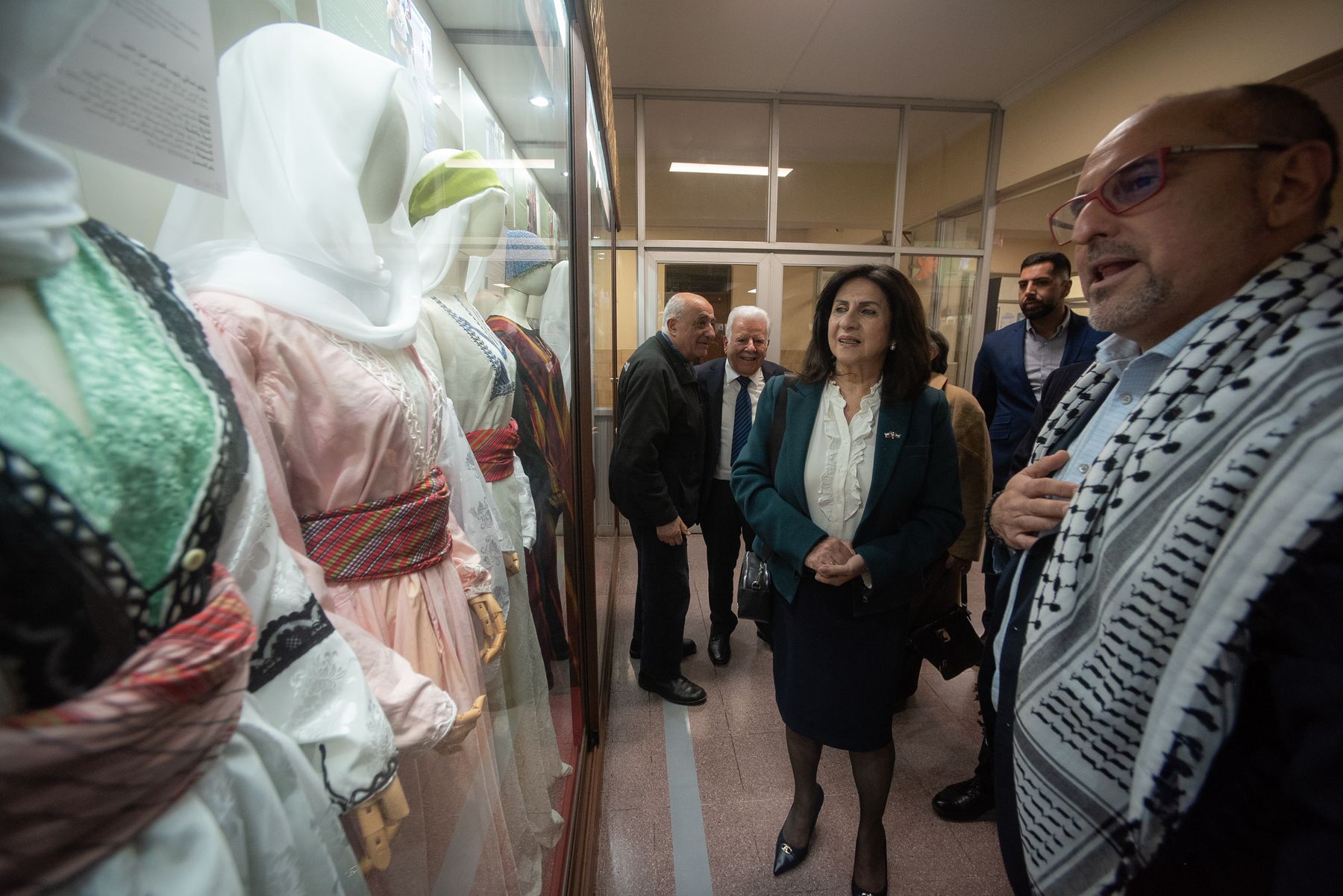 Vestidos tradicionales en una vitrina y visitantes al fondo