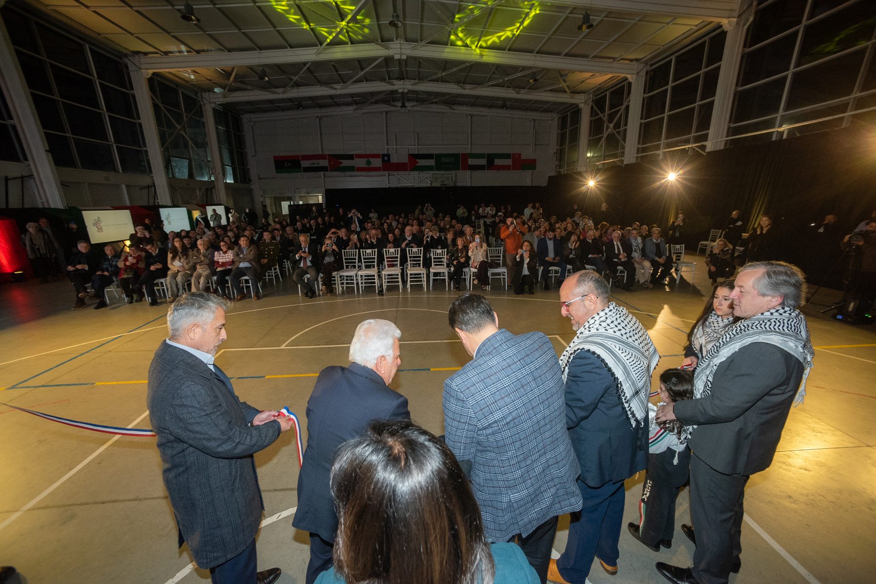 El grupo del corte de cinta, visto de espaldas, frente al público