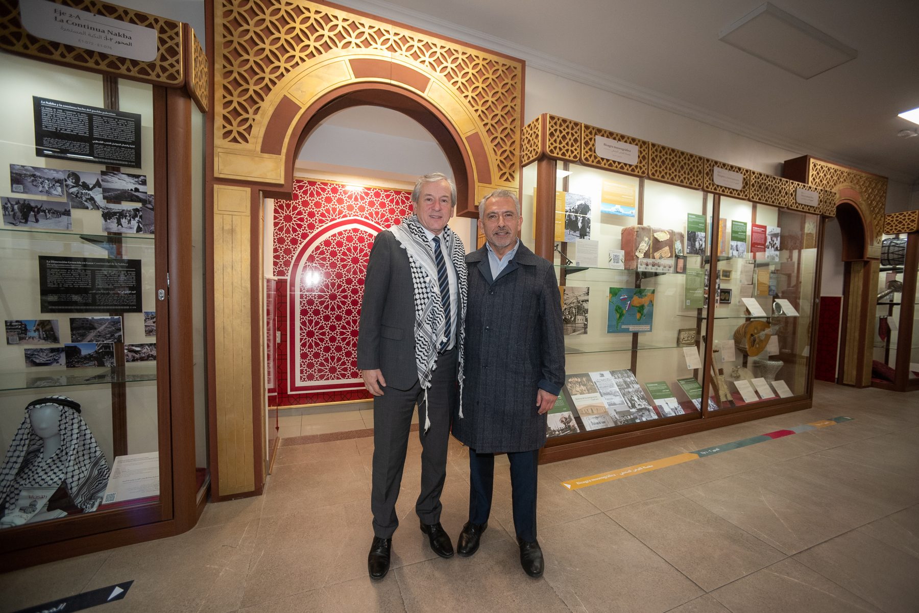 Dos hombres de pie bajo el arco de la sala