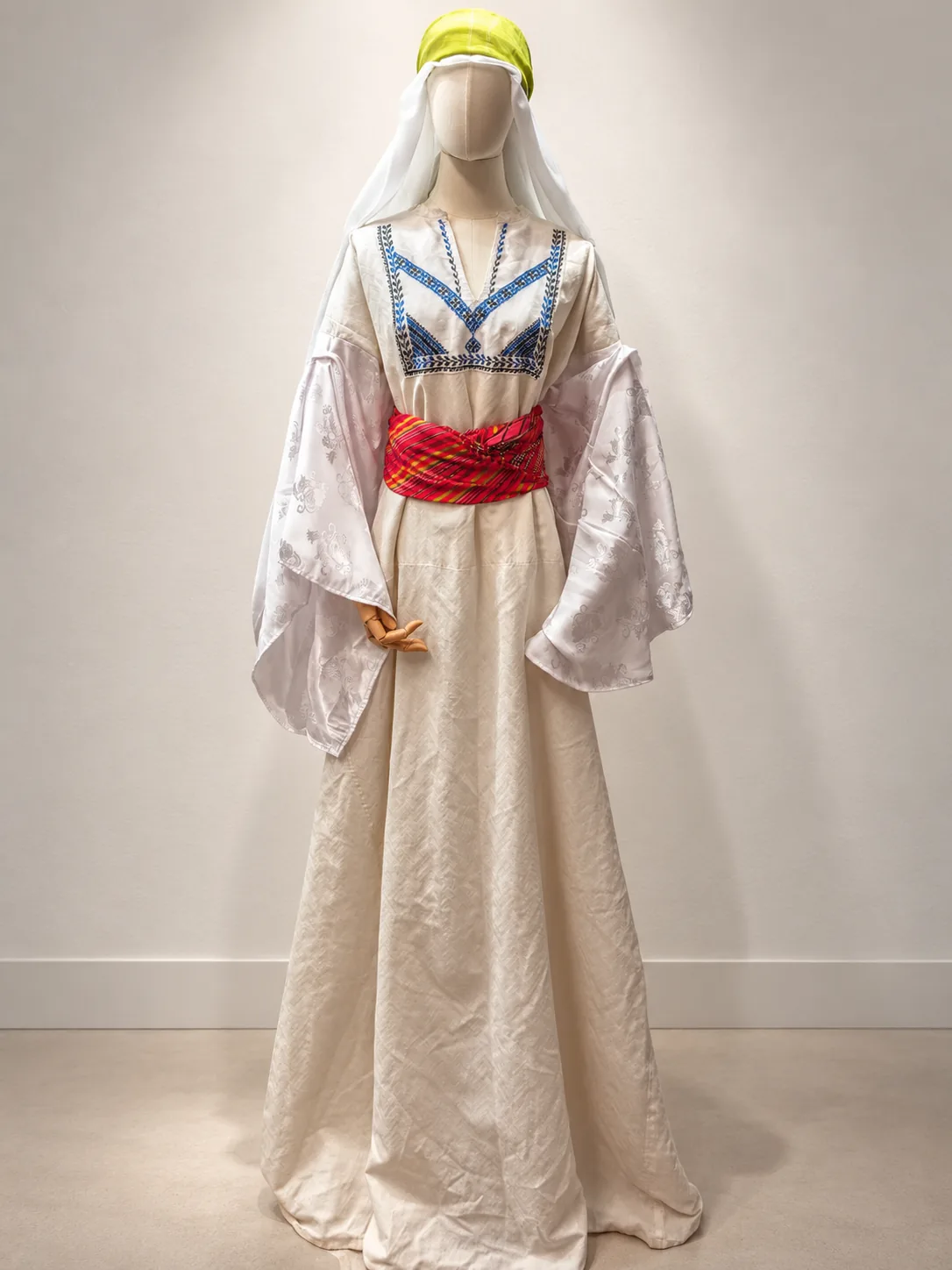 Vestido blanco con bordado azul en el pecho y mangas amplias